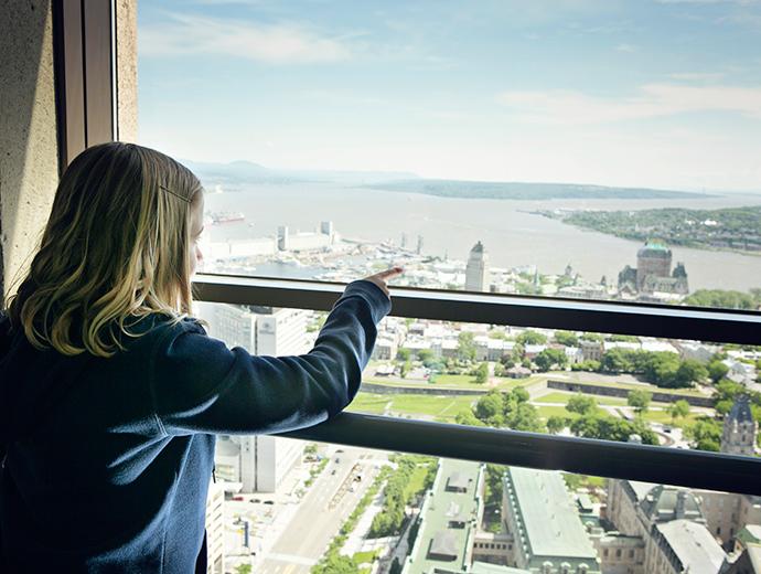 A young girl observes the view of Québec City from the Observatoire de la Capitale.