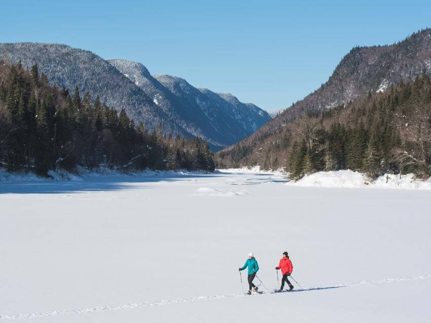 Two girls snowshoeing in the heart of the snow-covered Jacques-Cartier valley, in the Jacques-Cartier national park.