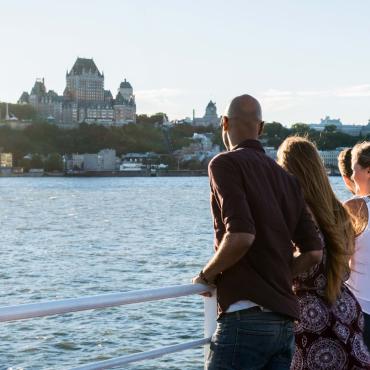 Groupe d'amis à bord du traversier Québec-Lévis, admirant le Vieux-Québec en été.