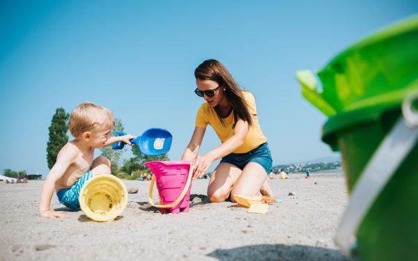Une mère et son enfant jouent à construire un château de sable à la plage de la Baie de Beauport.